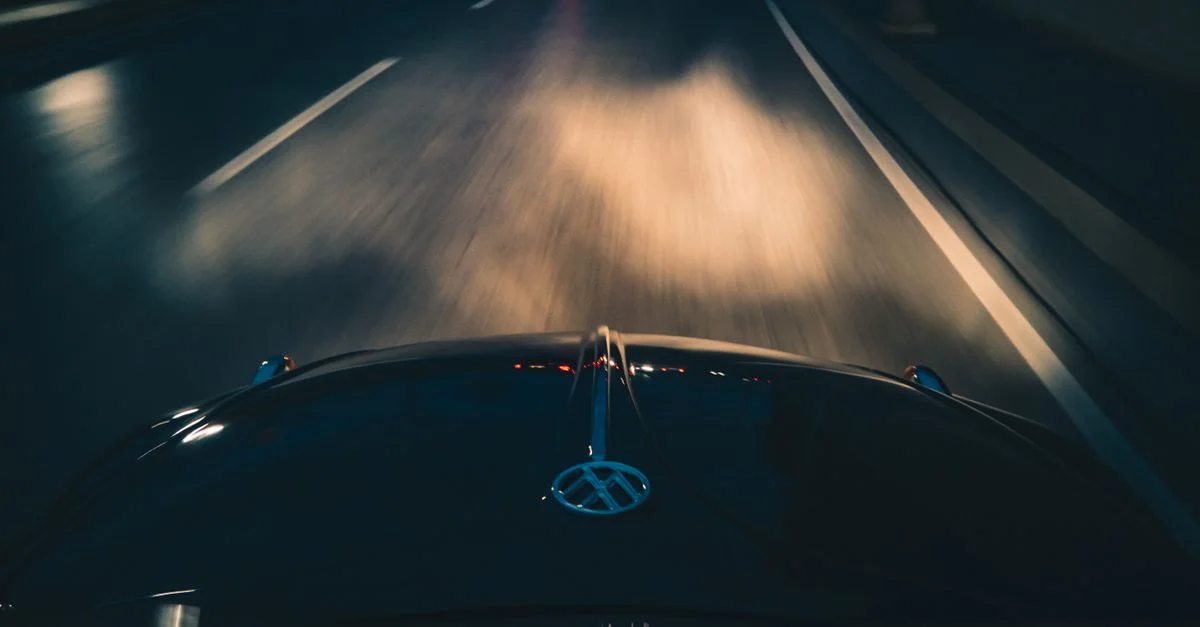 Image dynamique de conduite nocturne montrant un flou de mouvement alors qu'une voiture roule sur l'autoroute. Parfait pour des thèmes de transport.